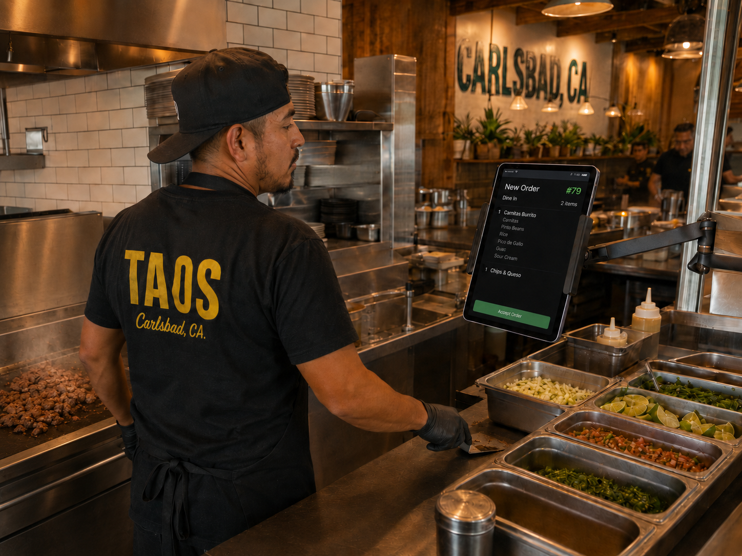 A taco cook reading an incoming order on the kitchen display monitor.
